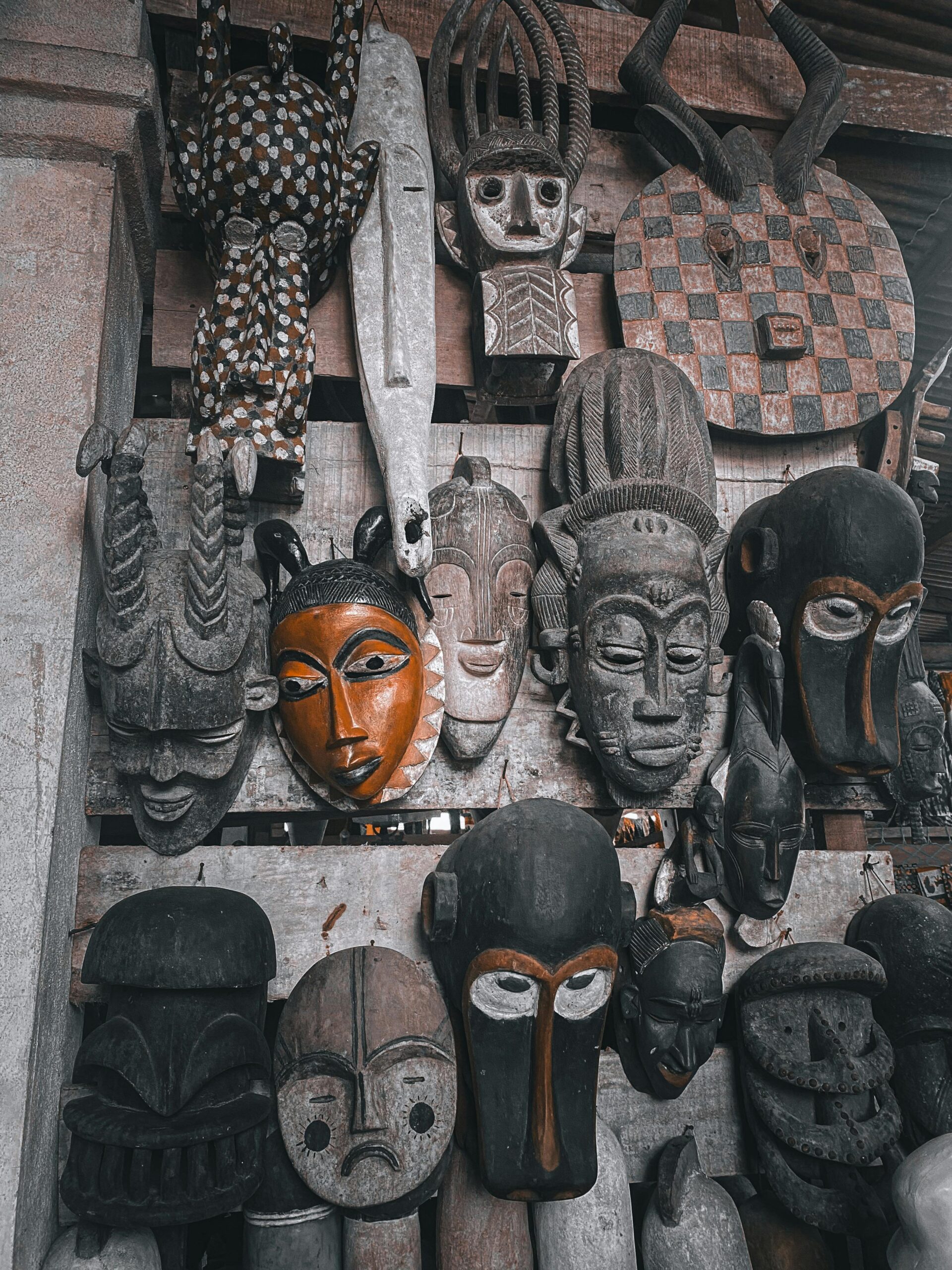 Colorful African tribal masks on display in Abidjan market, showcasing rich cultural heritage.