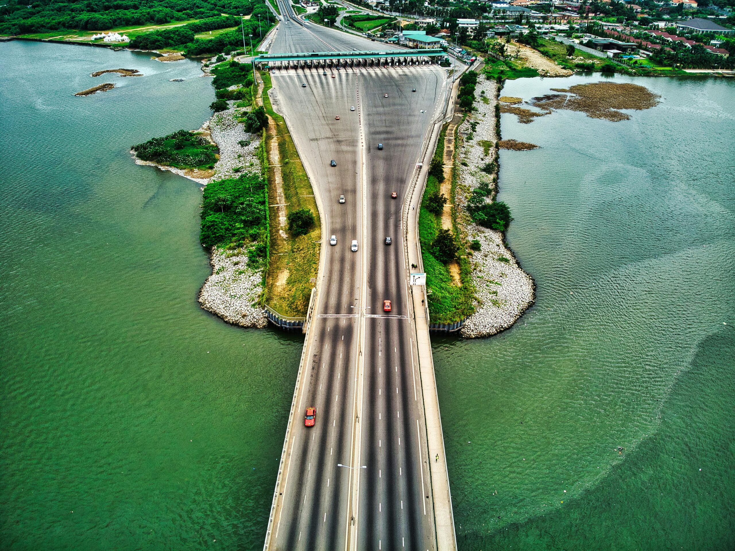 Aerial view of a busy bridge over a lake in Abidjan with motor vehicles in motion.